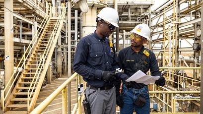  Two workers inspecting a paper at the Malongo Terminal facility.