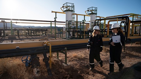 El Trapial tank battery 5. Two women walking along a pipeline.