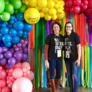 couple posing in front of colorful balloons